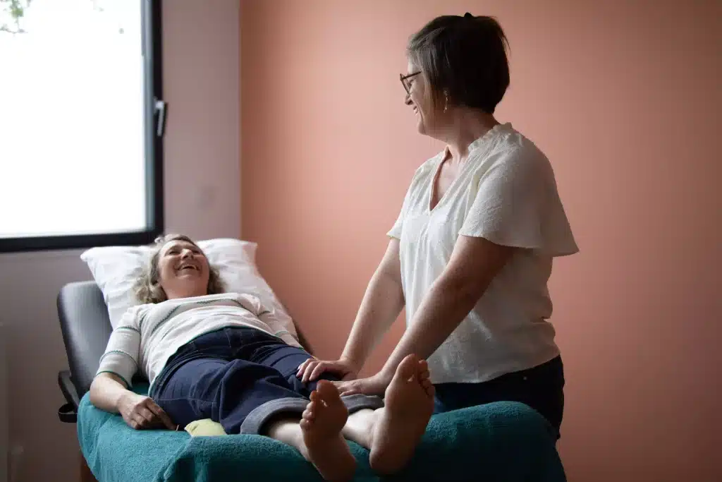 Cliente allongée et détendue sur la table de soin pendant une séance de réflexologie plantaire