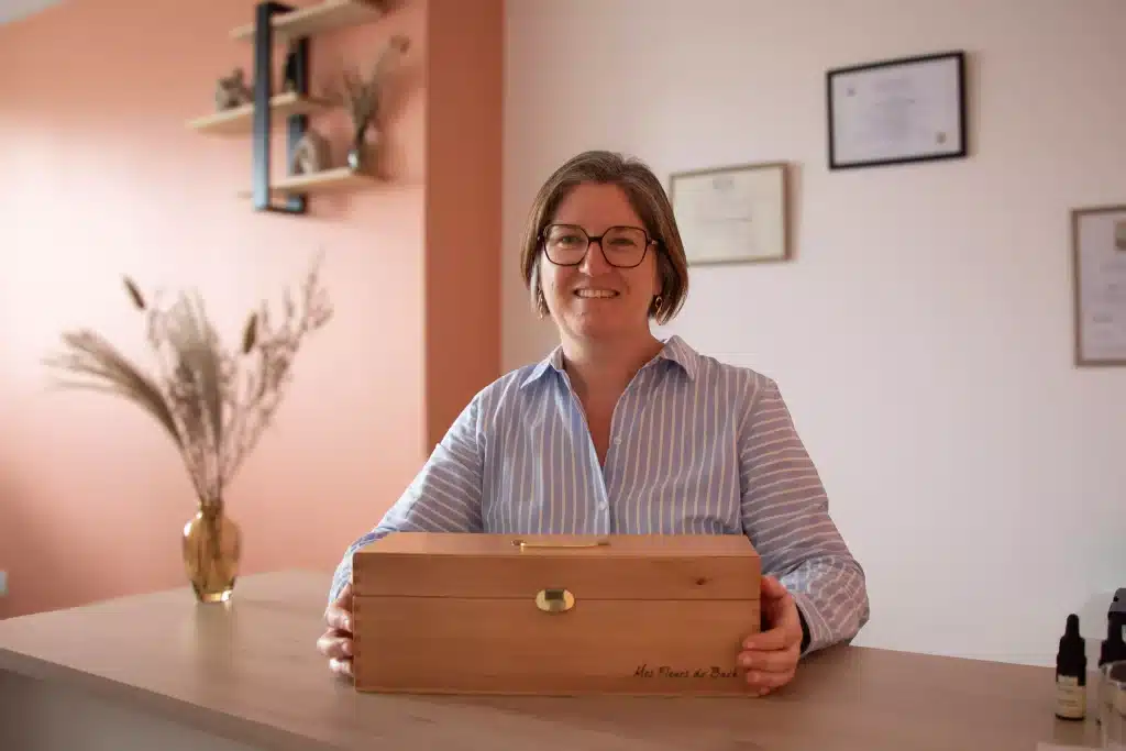 Virginie Bourdonnais présentant son coffret en bois d'élixirs de fleurs de Bach dans son cabinet